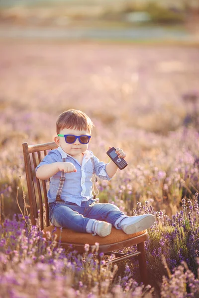 Modieuze jongetje met plezier in lavendel zomer veld. — Stockfoto