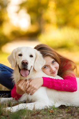 Onu köpek av köpeği sonbahar sahne ile yere oturan genç kız portresi