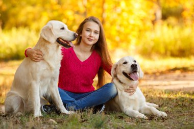 Onu köpek av köpeği sonbahar sahne ile yere oturan genç kız portresi