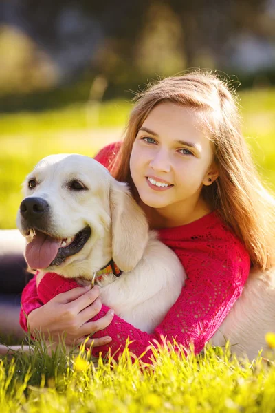 Retrato de la joven sentada en el suelo con su perro recuperador en la escena de otoño — Foto de Stock