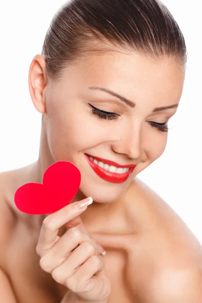 Портрет красивой красивой улыбающейся женщины с гламурным ярким макияжем и красным сердцем в руке — стоковое фото