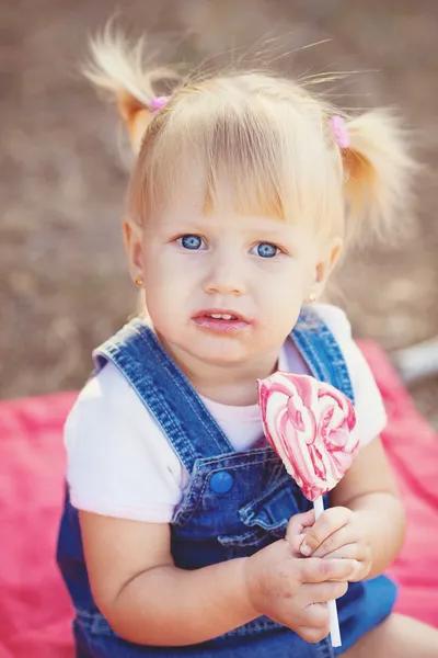 Bambina con grandi dolci passeggiate nel parco — Foto Stock