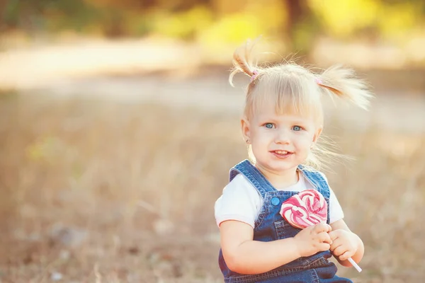 Niña con grandes paseos dulces en el parque — Foto de Stock