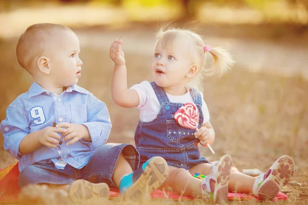 Милый мальчик и девочка играют вместе летом на открытом воздухе — стоковое фото