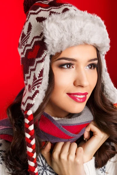 Portret van meisje in winterkleren met lichte make-up op een rode achtergrond — Stockfoto