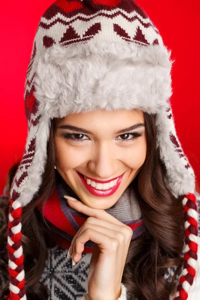 Portrait de fille en vêtements d'hiver avec un maquillage lumineux sur un fond rouge — Photo