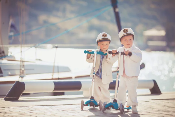Два маленьких мальчика катаются на скутере летом — стоковое фото