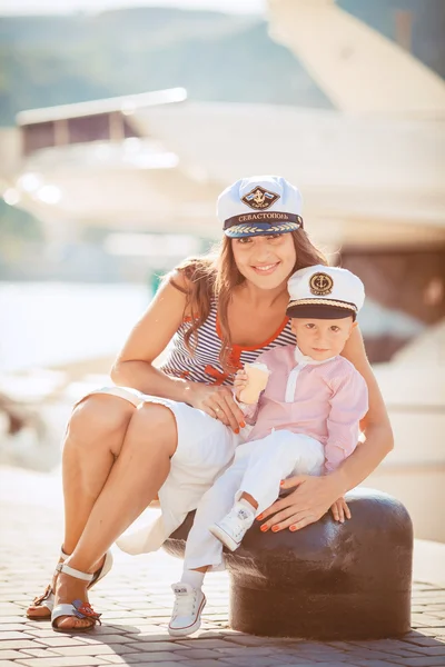 Porträtt av en mamma med sin son spela på bryggan vid havet i staden, stilleben Foto — Stockfoto