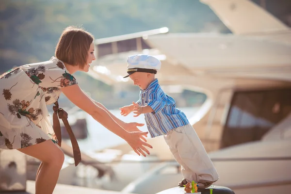 Mother and son playing on the quay near the sea — Stock Photo, Image