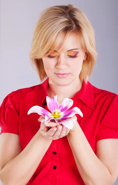 Jonge mooie vrouw met roze bloem. studio portret — Stockfoto