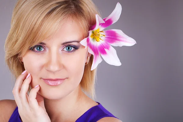 Portrait of cute young woman with floewer near her face. Studio portrait — Stock Photo, Image