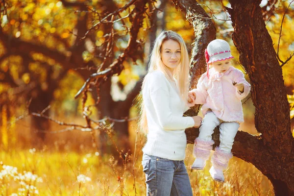 Schöne junge Mutter und ihre Tochter im Park — Stockfoto