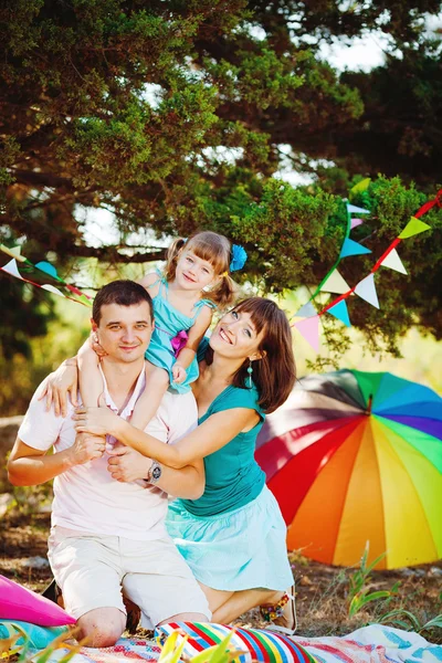 Gelukkig jonge gezin met kind buiten rusten in zomer park — Stockfoto