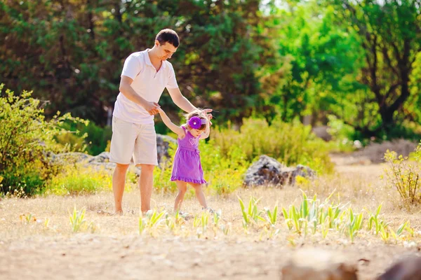 Glückliche junge Familie mit Kind ruht sich im Sommerpark aus — Stockfoto