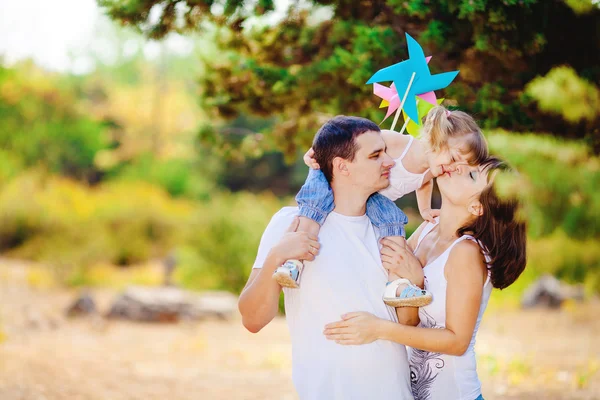 Gelukkig jonge gezin met kind buiten rusten in zomer park — Stockfoto