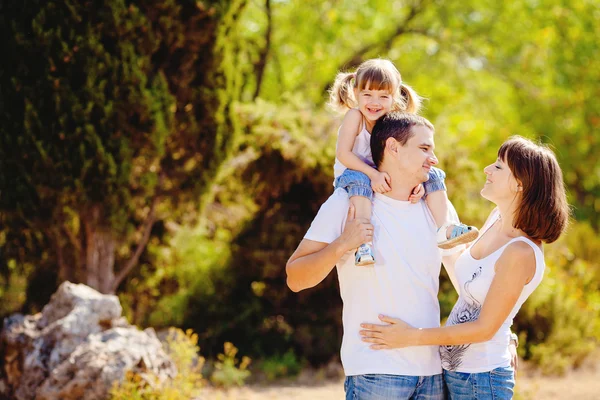 Glückliche junge Familie mit Kind ruht sich im Sommerpark aus — Stockfoto