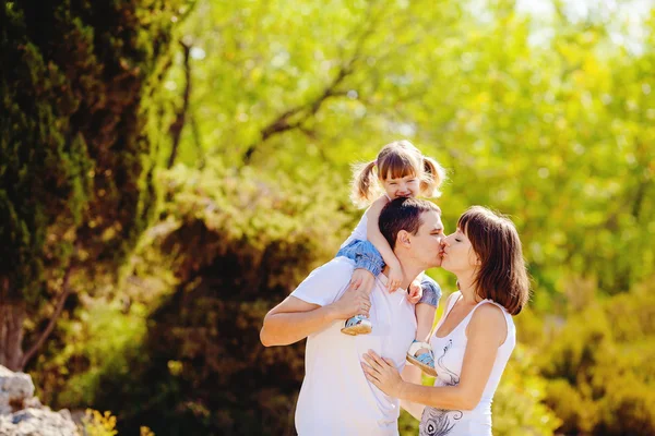 Happy young family with child resting outdoors in summer park Royalty Free Stock Photos