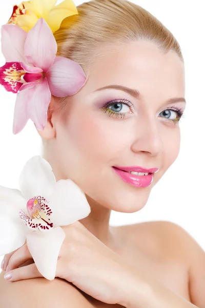 Портрет красивой женщины с орхидеей Цветок в ее прическе.Красивая модель женщина лицо. Идеальная кожа. Профессиональный макияж. Изолированный на белом фоне — стоковое фото