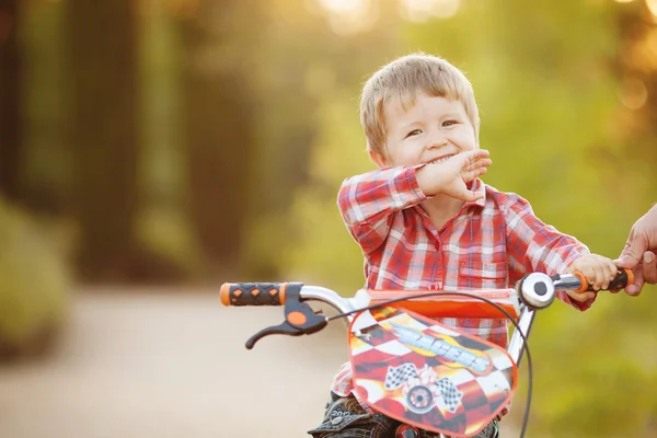 Happy boy on a bicycle in a summer park — Stock Photo, Image