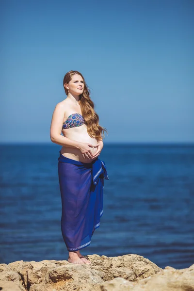Giovane donna incinta respira l'aria fresca di mare su uno sfondo di montagne — Foto Stock