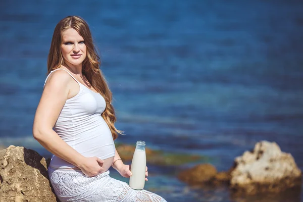 Jeune femme enceinte respire l'air frais de la mer sur un fond de montagnes — Photo