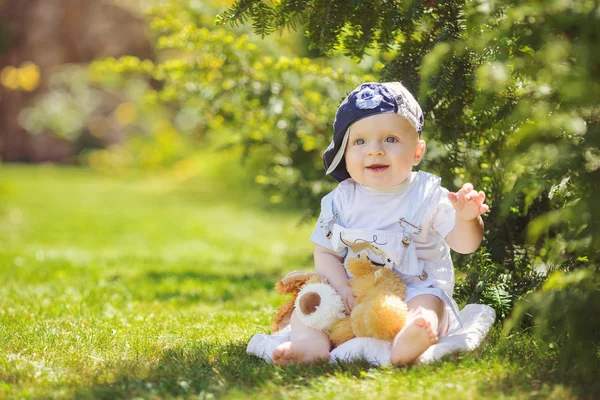 Retrato de menino bonito sentado na grama — Fotografia de Stock