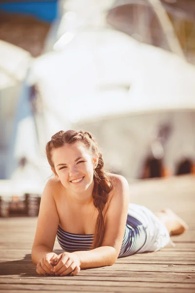 Junge Frau an einer Uferpromenade am Rande eines Sees — Stockfoto