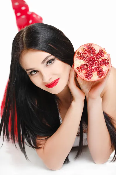 Brunette girl with garnet fruit in studio — Stock Photo, Image