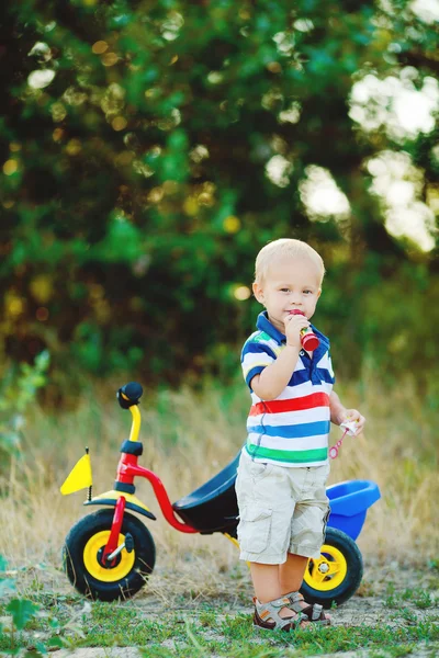 Маленький улыбающийся мальчик на игрушечном велосипеде — стоковое фото