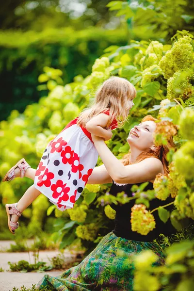 Madre e hija jugando en el verde parque de verano al aire libre — Foto de Stock