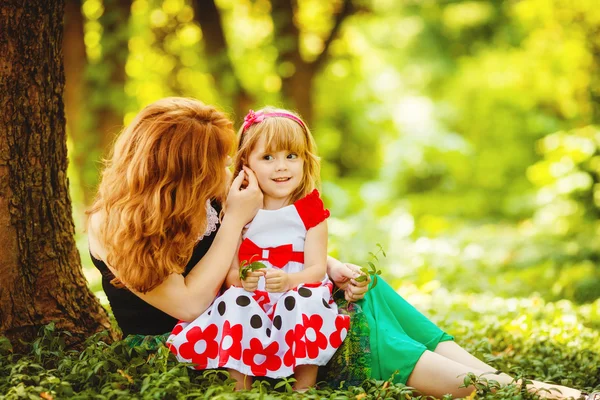 Moeder en dochter spelen in groene zomer park buiten — Stockfoto