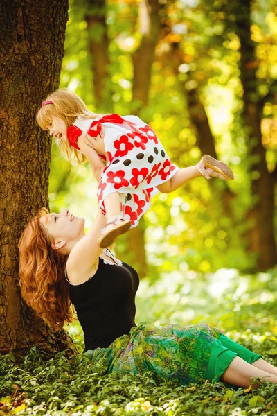 Madre e hija jugando en el verde parque de verano al aire libre — Foto de Stock