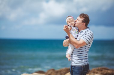 Eğleniyor mavi deniz kenarında yaz aylarında adam ve bebek çocuk mutlu bir aile portresi