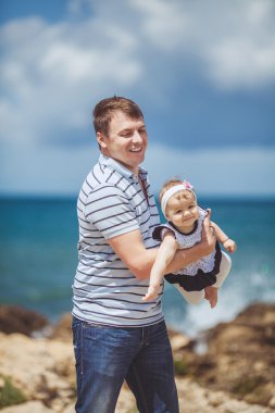 Eğleniyor mavi deniz kenarında yaz aylarında adam ve bebek çocuk mutlu bir aile portresi