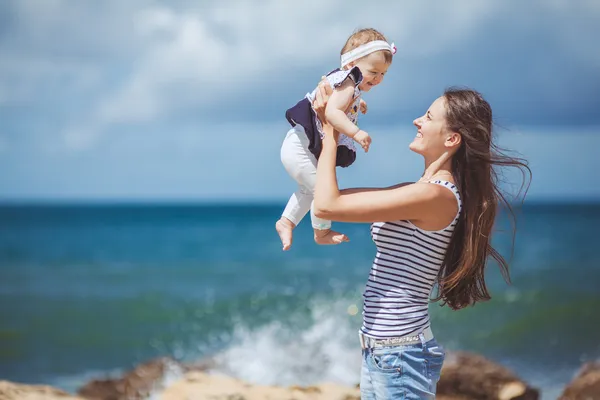 Портрет щасливої сім'ї двох матерів і дитини, що розважаються на березі моря — стокове фото