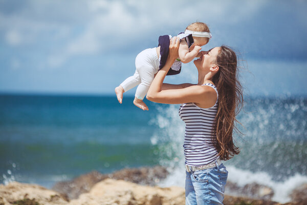 Portrait of Happy Family of two mother and child having fun by the Sea shore