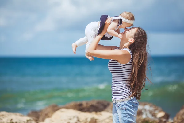 İki anne ve çocuk tarafından deniz kıyısında eğleniyor, mutlu bir aile portresi — Stok fotoğraf