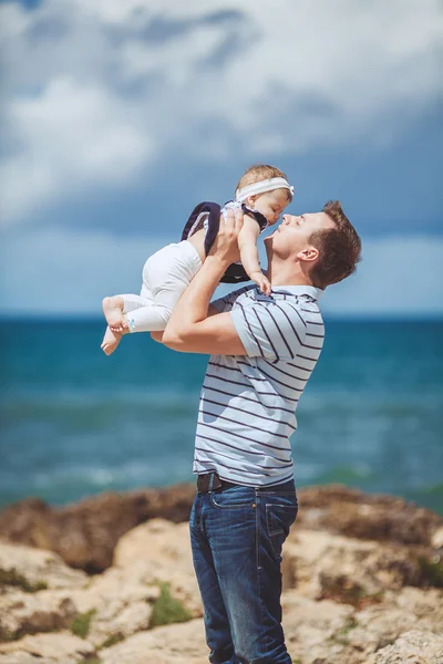 Portrait of a Happy family of man and infant child having fun by the blue sea in summertime — Stock Photo, Image