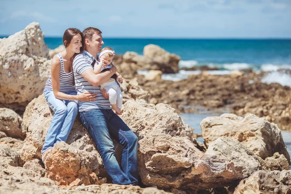 Retrato de familia de tres divirtiéndose juntos por la orilla del mar y disfrutando de la vista. Al aire libre —  Fotos de Stock