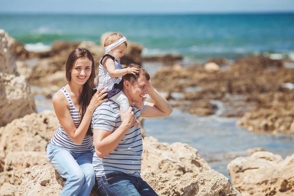 Portret rodziny trzy zabawy razem przez brzeg oceanu i z widokiem. Na zewnątrz — Zdjęcie stockowe