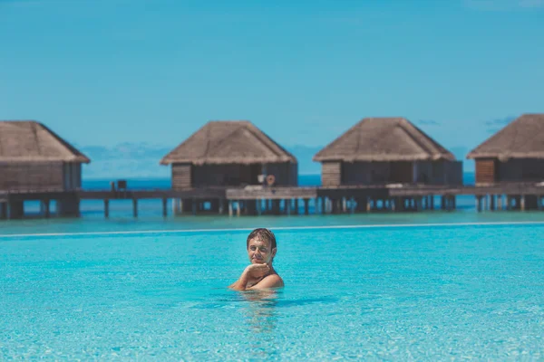 Joven en la piscina y el océano en el fondo. Maldivas — Foto de Stock