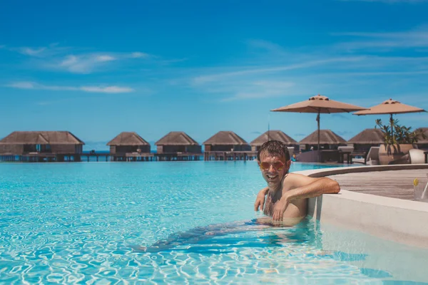 Giovane in piscina e nell'oceano sullo sfondo. Maldive — Foto Stock