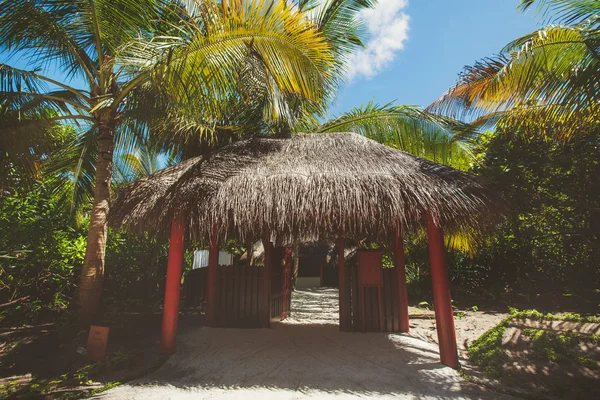 Landscape of tropical island beach with perfect sky, palms, traditional buildings — Stock Photo, Image