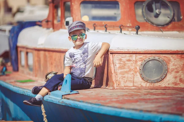 Chłopak ładny mały żeglarz o wentylator w pobliżu łodzi na molo, w pobliżu morza. odkryty. — Zdjęcie stockowe