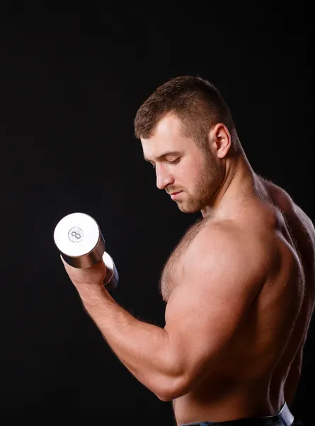 Ajuste o homem muscular exercitando com halteres — Fotografia de Stock