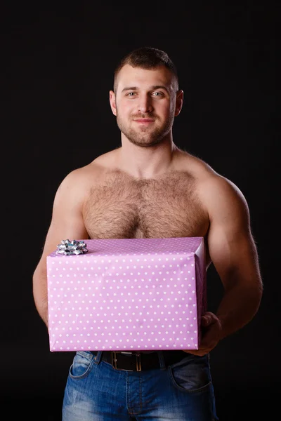 Afbeelding van gespierde man met Kerstmis geschenken, geïsoleerd op zwart — Stockfoto