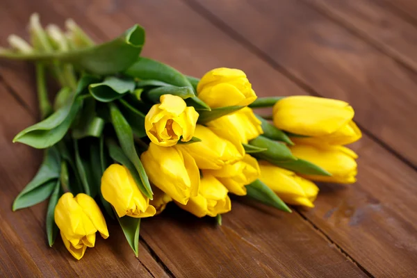 Banch of Yellow tulips lying on wooden boards — Stock Photo, Image