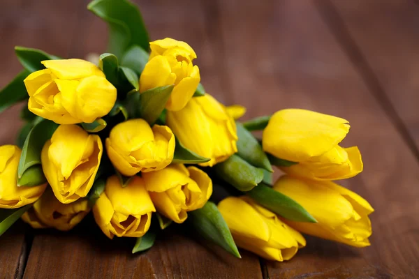 Banch of Yellow tulips lying on wooden boards