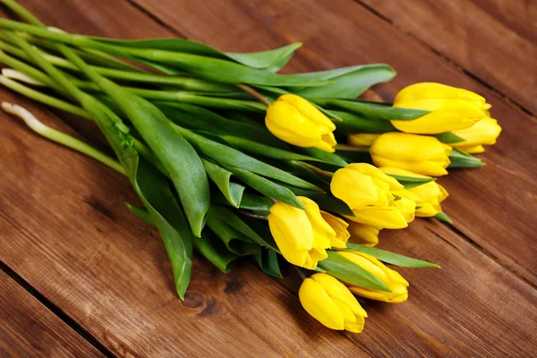 Banch of Yellow tulips lying on wooden boards — Stock Photo, Image