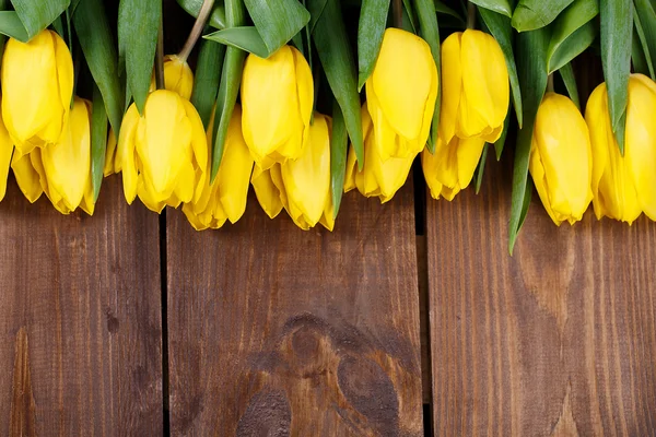 Beautiful yellow tulips on wooden background. Top view, copy space — Stock Photo, Image